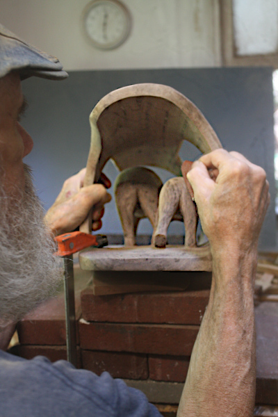 Woodcarver sanding bear butts.