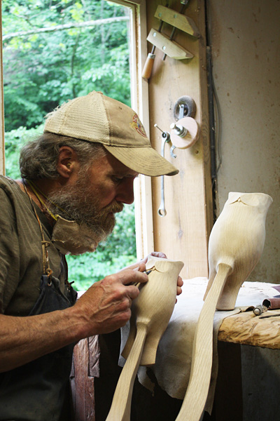 finishing a pair of owls 					carved from red oak